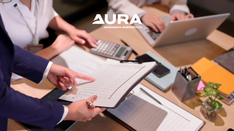 Consultores de Aura Ingeniería analizando un informe de auditoría energética para una empresa.